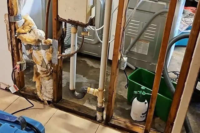 Laundry room wall opened to the studs around a burst supply pipe